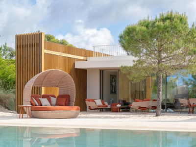Palma rust outdoor daybed with matching outdoor furniture beside a pool
