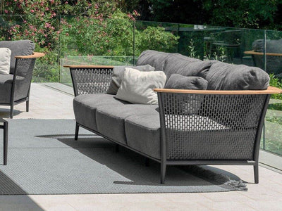 Pascal Outdoor Lounge 3 Seater Sofa with wooden armrests and grey cushions on patio.