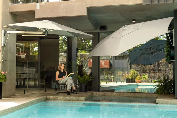 Retreat Wall-Mounted Outdoor Umbrella providing shade by poolside in modern outdoor space