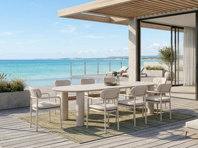 Scotland Outdoor Ceramic Table with a sand-coloured ceramic top and matching powder-coated aluminium frame, shown with cushioned dining chairs.