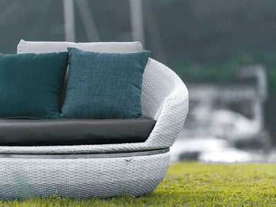 Space Daybed Outdoor Swivel Lounge Chair on grassy patio with white wicker and teal cushions.