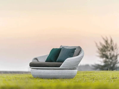 Space Daybed Outdoor Swivel Lounge Chair on grass with sunset background.