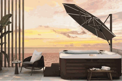 SU4 Tilting Offset Outdoor Umbrella providing adjustable shade next to a hot tub on a patio at sunset