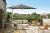 SU4 Tilting Offset Outdoor Umbrella providing adjustable shade over modern outdoor seating on a sunny patio