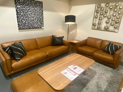 Sunrise Leather Lounge Suite clearance sale caramel leather 2.5 and 2 seater sofas with black cushions and wooden coffee table