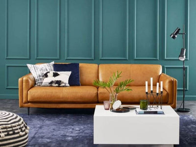 Sunrise 2.5 Seater Leather Sofa in elegant brown leather, styled in a modern living room with decorative cushions and a white coffee table.