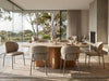 Theo Dining Chair with beige upholstered fabric, rounded cushioned seat and back, and slim metal legs in a muted grey finish.
