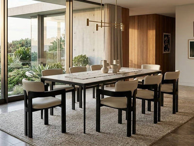 Ceramic Dining Table with a pale stone-patterned top and black metal legs, paired with cream upholstered chairs.