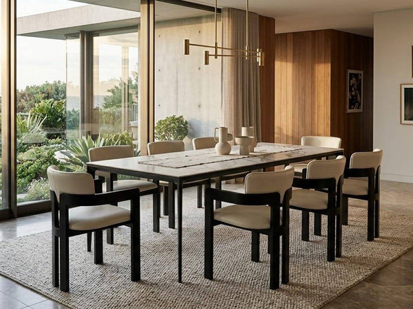 Ceramic Dining Table with a pale stone-patterned top and black metal legs, paired with cream upholstered chairs.